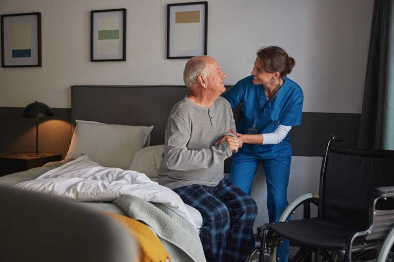 An older adult receives helpful assistance with daily activities from a caregiver in a comfortable home setting.